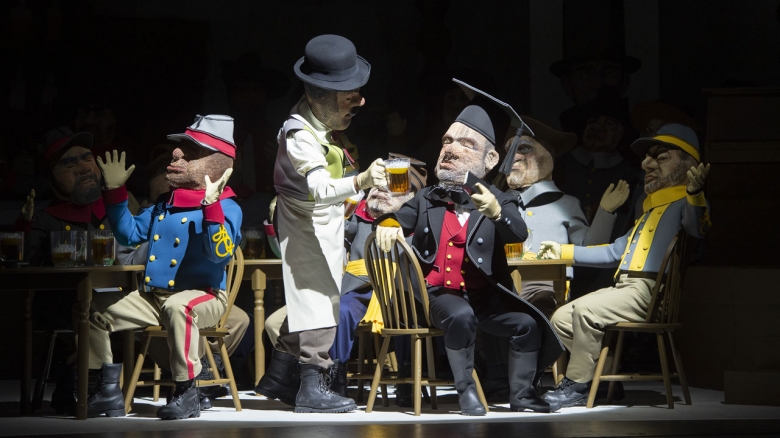 Dietrich Volle (Ein Alkalde; stehend mit Bierkrug), Christopher Maltman (Don Carlo di Vargas; in schwarzem Mantel und roter Weste), Chor und Extrachor der Oper Frankfurt